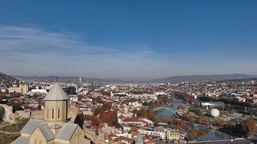 Aerial view of Tbilisi old town buildings and Narikala fortress landmark on hill. Georgia 2022