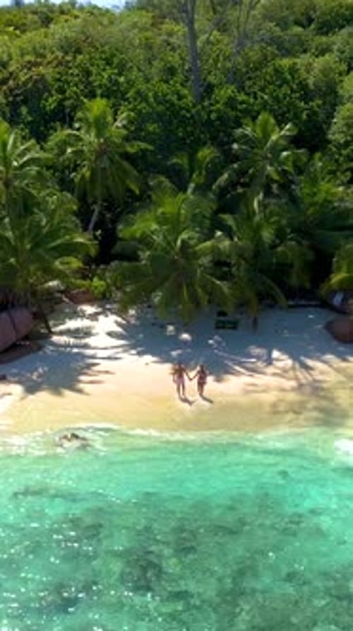 Anse Lazio Praslin Seychelles Young Couple Men and Woman on a Tropical Beach During a Luxury