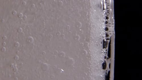 Bubbles Rising from Cube in Glass Macro Shot