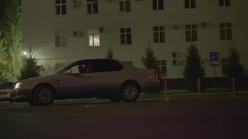 Sedan Under Lighting Quiet Street Scene with Cautious Driver in City Environment Silent Night Urban