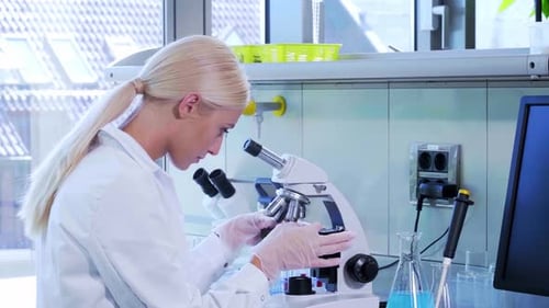 Female Scientist Uses Microscope in Modern Lab