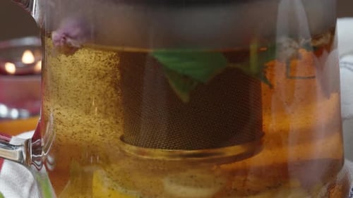 I pour boiling water into the teapot, small particles of tea rise up. close-up.