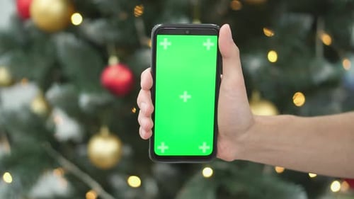 Hand Holding Smartphone with Green Screen on Chroma Key