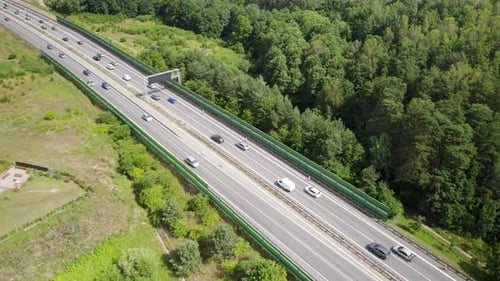 Aerial drone shot of rural highway with traffic on asphalt at summer - Many vehicles during journey