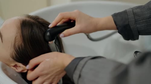Frau lässt sich im Salon die Haare waschen