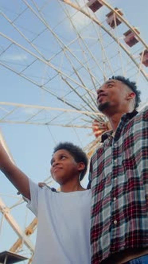 Father and Son at the Ferris Wheel Enjoying Day