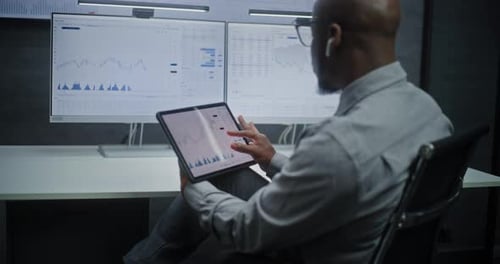 Stock Exchange Trader Monitoring RealTime Stocks and Exchange Market Charts on Digital Tablet