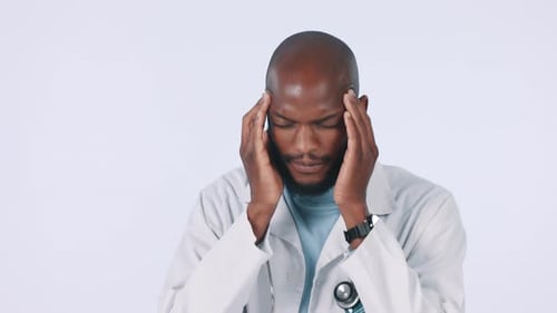 Headache, doctor and stress of man in studio with burnout, pain and healthcare challenge on white