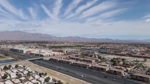 Slow aerial forward of Traffic on Highway in Summerlin Cityscape, suburb of Las Vegas during beautif