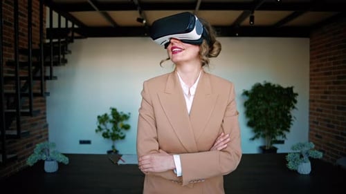 Woman smiling while using a Virtual Reality headset in an office