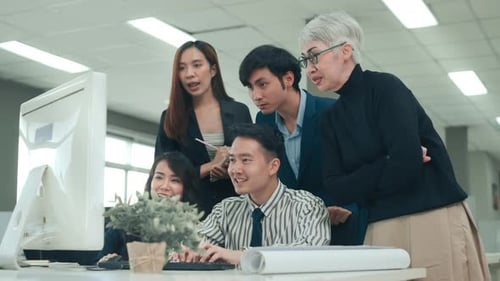 Diverse Team Celebrates Success at Office Computer