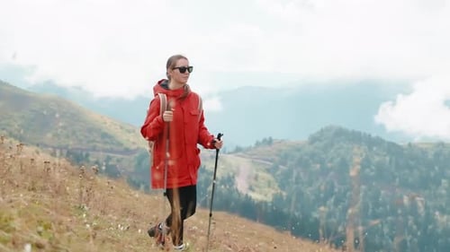 Woman Hiking Down Mountain with Trekking Poles