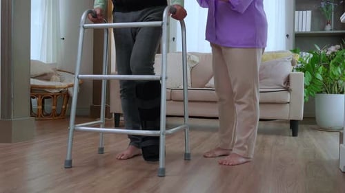 Adult Woman Helping Senior Man with Walker