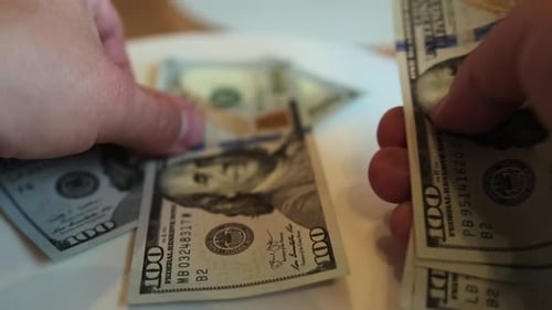 Male hands count US Dollar bills or paying in cash on white background, close up. US money banknotes