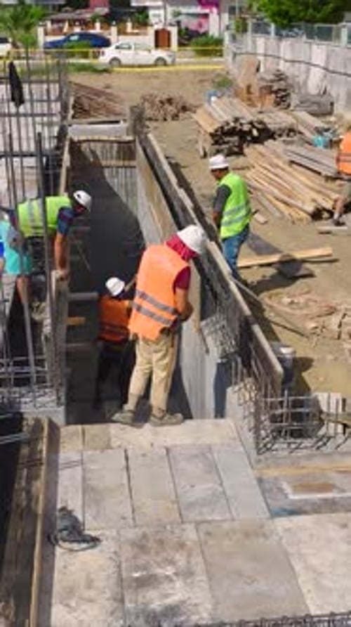 Los trabajadores de vídeo vertical construyen paredes con habilidad y precisión en una concurrida obra que avanza