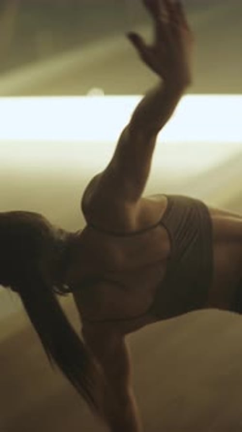 Wellness Sportlicher Frauentanz in einem Studioraum Flexible Frau führt einen Dehntanz vertikal durch