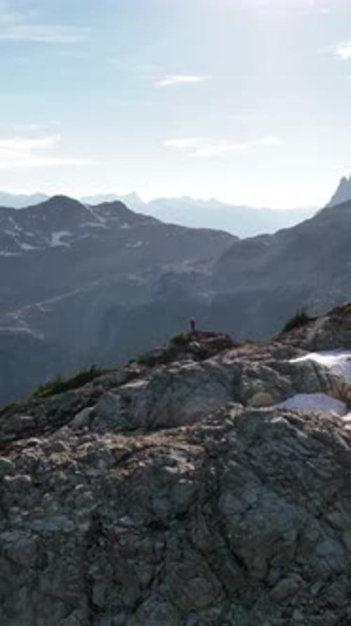 Solo Hiker Enjoys Panoramic Views from a Rocky Peak in Majestic British Columbia, Canada