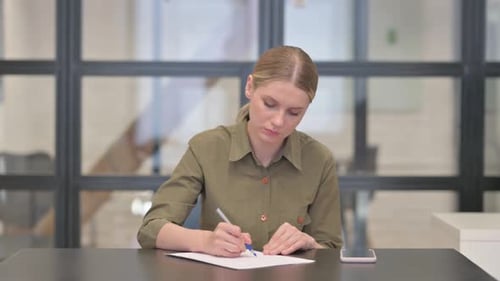 Mature Adult Woman Writing a Letter in Office