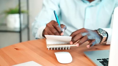 Man Write Notes in Notepad in Workplace