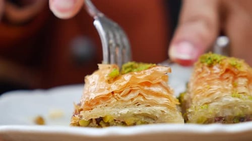 Découper le baklava à dessert turc à l'aide d'un couteau et d'une fourchette