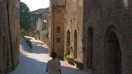 Tourist Walking Down a Medieval Street in Tuscany