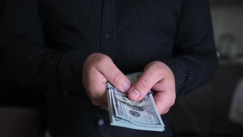 Hands counting stack of one hundred dollar bills