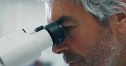 Das Porträt eines männlichen Wissenschaftlers analysiert eine Probe, um die DNA und Moleküle mit dem Mikroskop zu extrahieren