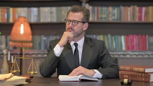 Pensive Middle Aged Lawyer Reading Book in Office
