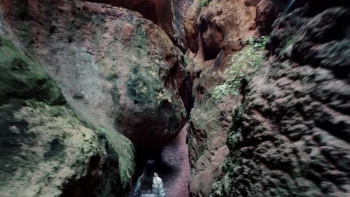 Höhlenerkundung, Erkundung einer Höhle. Junge Entdeckerin geht durch einen schmalen Pfad in Höhlen