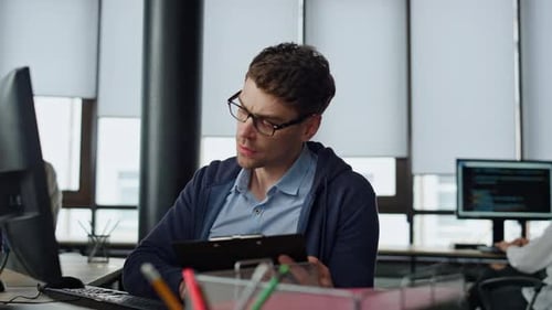 IT Manager Analysing Online Report. Thoughtful Software Engineer Making Notes Looking Problem