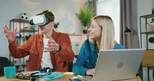 Schöner Mann mit 3D-Brille beobachtet futuristische Visionen, die von seiner Freundin für ihn ausgewählt wurden