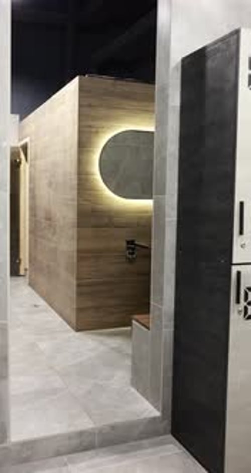 Vestiaire de salle de sport moderne avec miroir, sèche-cheveux et banc. La caméra avance