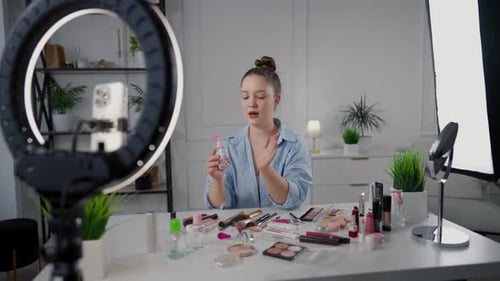 Retrato de una mujer bloguera de belleza en el estudio cuando transmitía en línea en las redes sociales la publicidad de