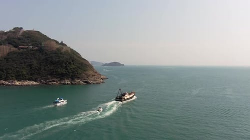 Large Fishing Ship leaving Hing Kong bay marina, Aerial follow footage.
