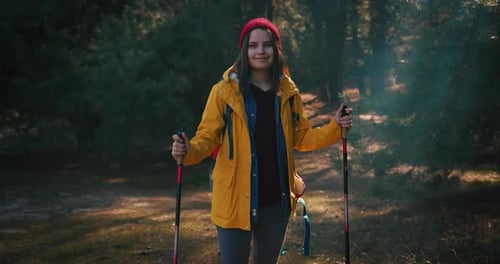 Backpacker Hiker Girl with Hiking Poles Walking Between Trees in a Mountain Forest Hispanic Teenager