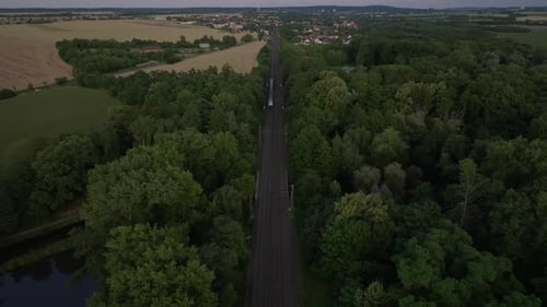 Luftaufnahme eines elektrischen Zuges, der sich in der Dämmerung nähert