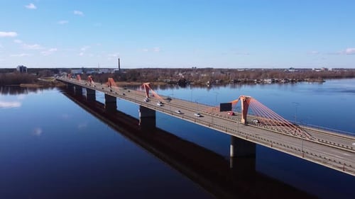 Aerial wide shot of a bridge over a river on the outskirts of the city. Cable-stayed bridge over a r
