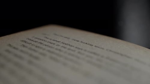 Close up through an open book page with out of focus words