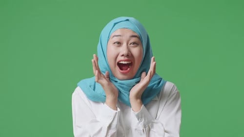 Close Up Of Asian Muslim Woman Smiling And Saying Wow While Standing In The Green Screen