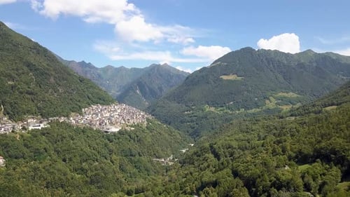 Helicopter view of European village in the middle of the mountains in Premana, Dolomites, Italy, 4K
