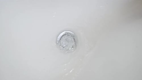 El agua se drena en el lavabo del baño y se arremolina en Cámara lenta
