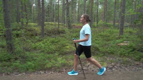 Active Woman Doing Nordic Walking in a Park