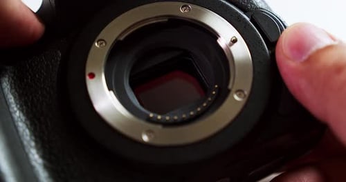Close-up of a camera body while the technician is checking its sensor to see if it needs some cleani