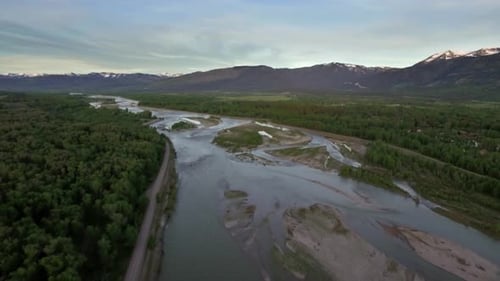 Drone View of River and Forest by Majestic Mountains Above