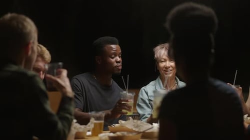 Friends Toast Drinks at Nighttime Gathering