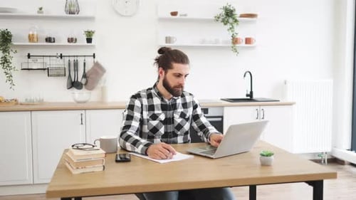 Man Working on Laptop in Bright Kitchen
