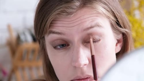 Woman Applying Makeup Eyeshadow with Brush Close Up