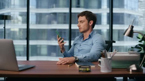 Man talking on phone sitting at desk