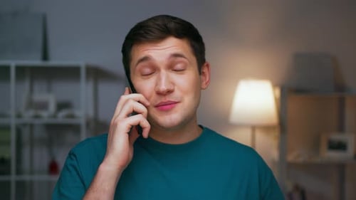Happy Man Talking on Mobile Phone at Home