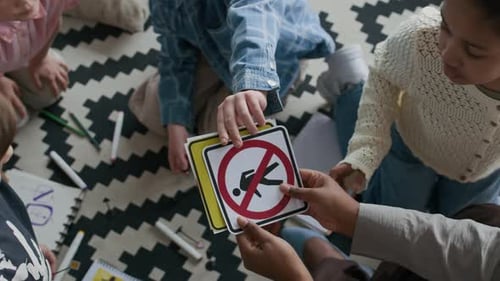 Estudiantes que toman tarjetas con símbolos de tráfico que sostiene el profesor durante la lección de seguridad vial